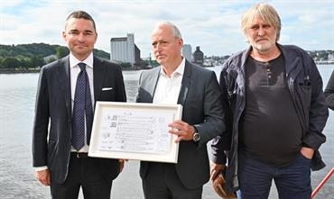 Lars Windhorst (left), Martin Hammer (middle) and Thomas Jansen (right) with a framed GA plan of the new ro-ros Windhorst plans to build at the 'new' FSG. © FSG